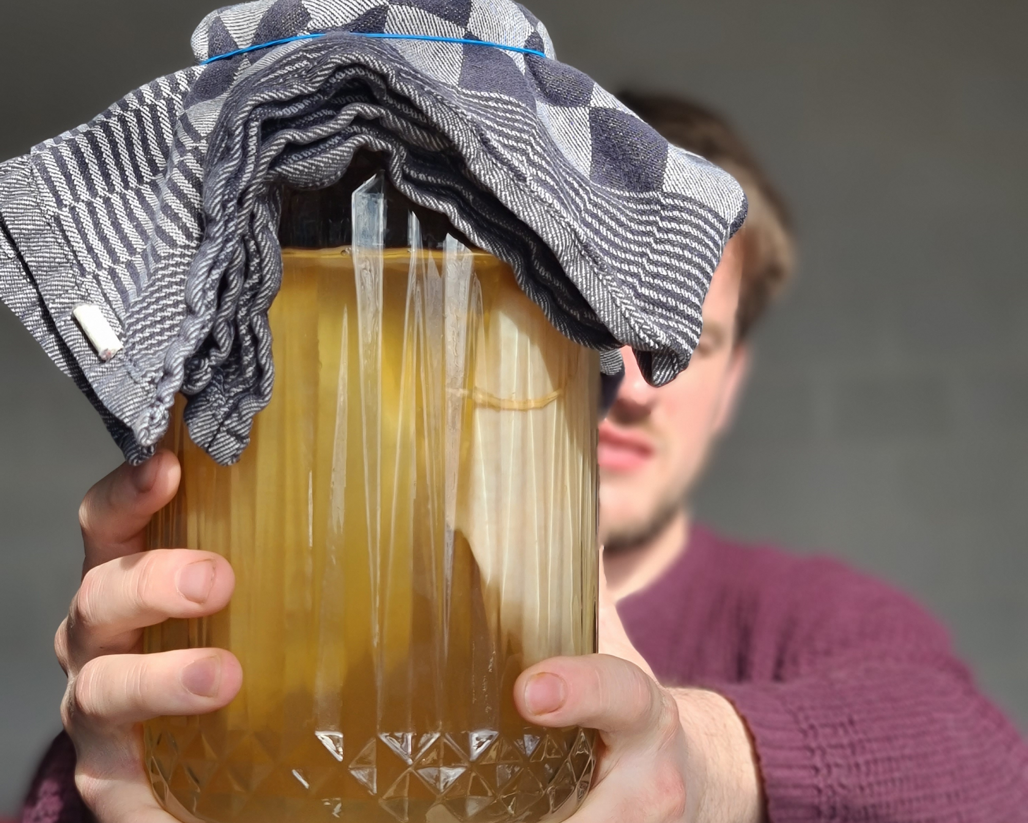 Kombucha in een pot met zwam en doek. Vastgehouden door brouwer Joris van den Broek van Untamed Kombucha