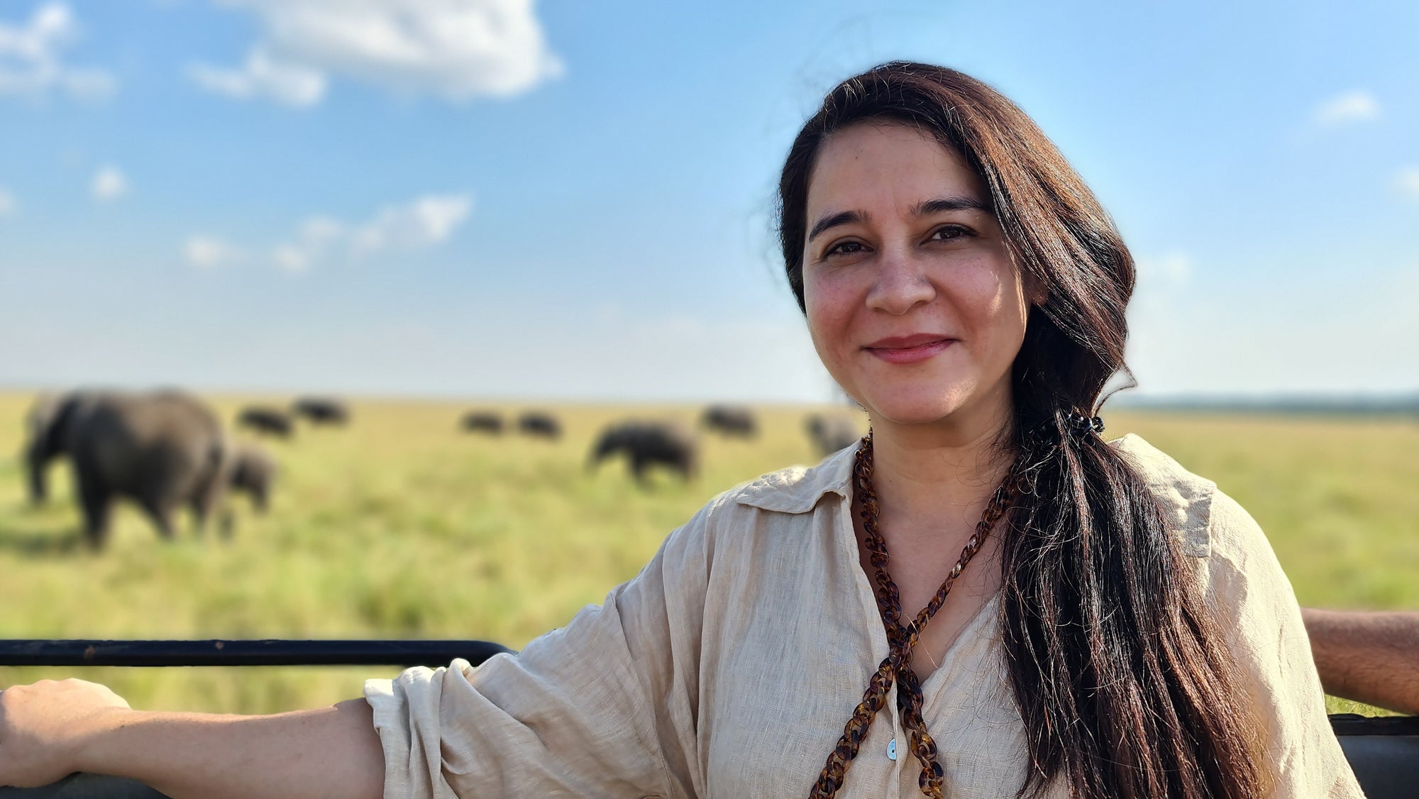 Untamed Kombucha - Sameen Ansari with elephants in the background in Kenya, Africa