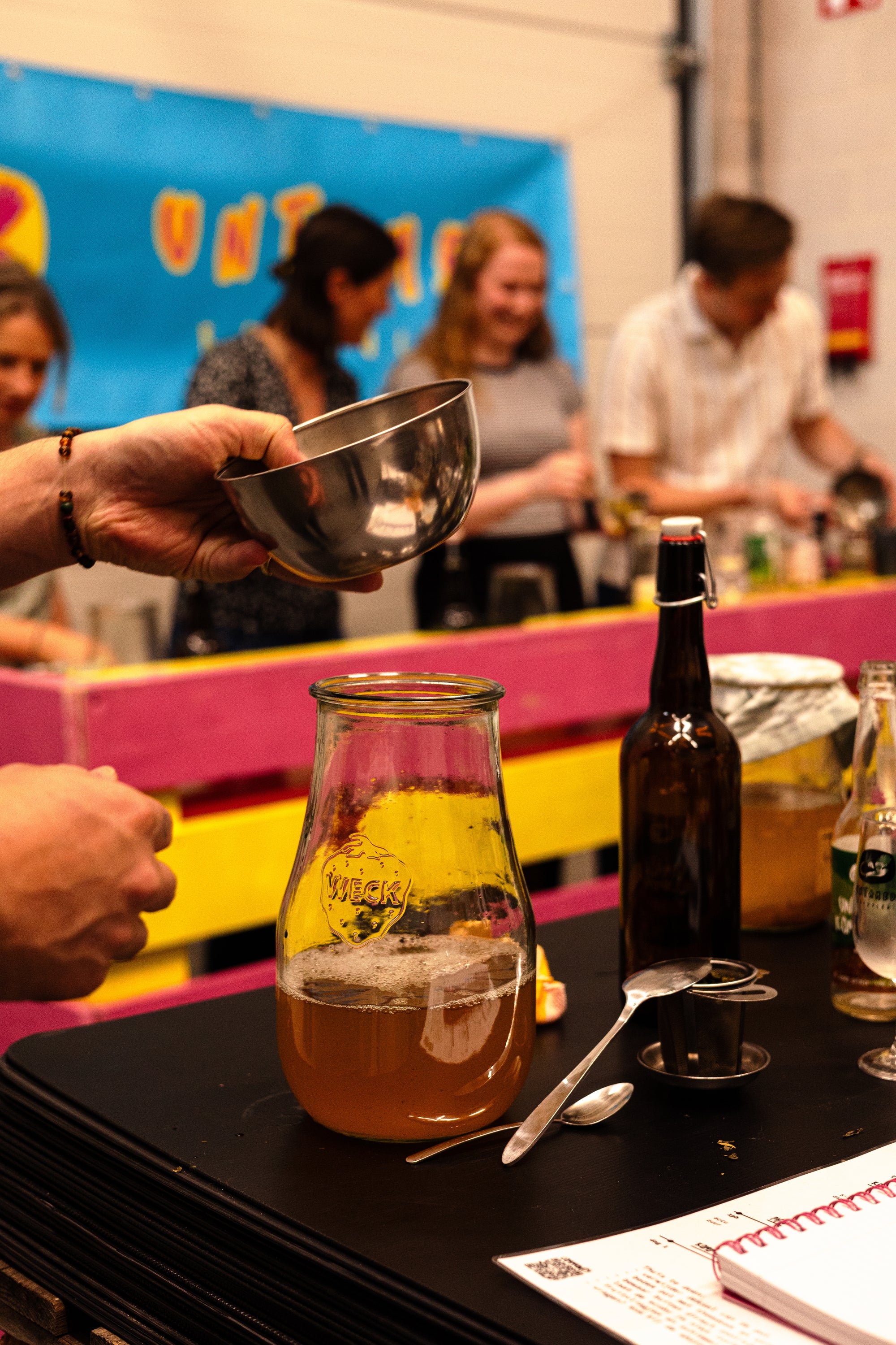 De start van het kombucha maken door zoete thee toe te voegen aan een glazen pot met SCOBY