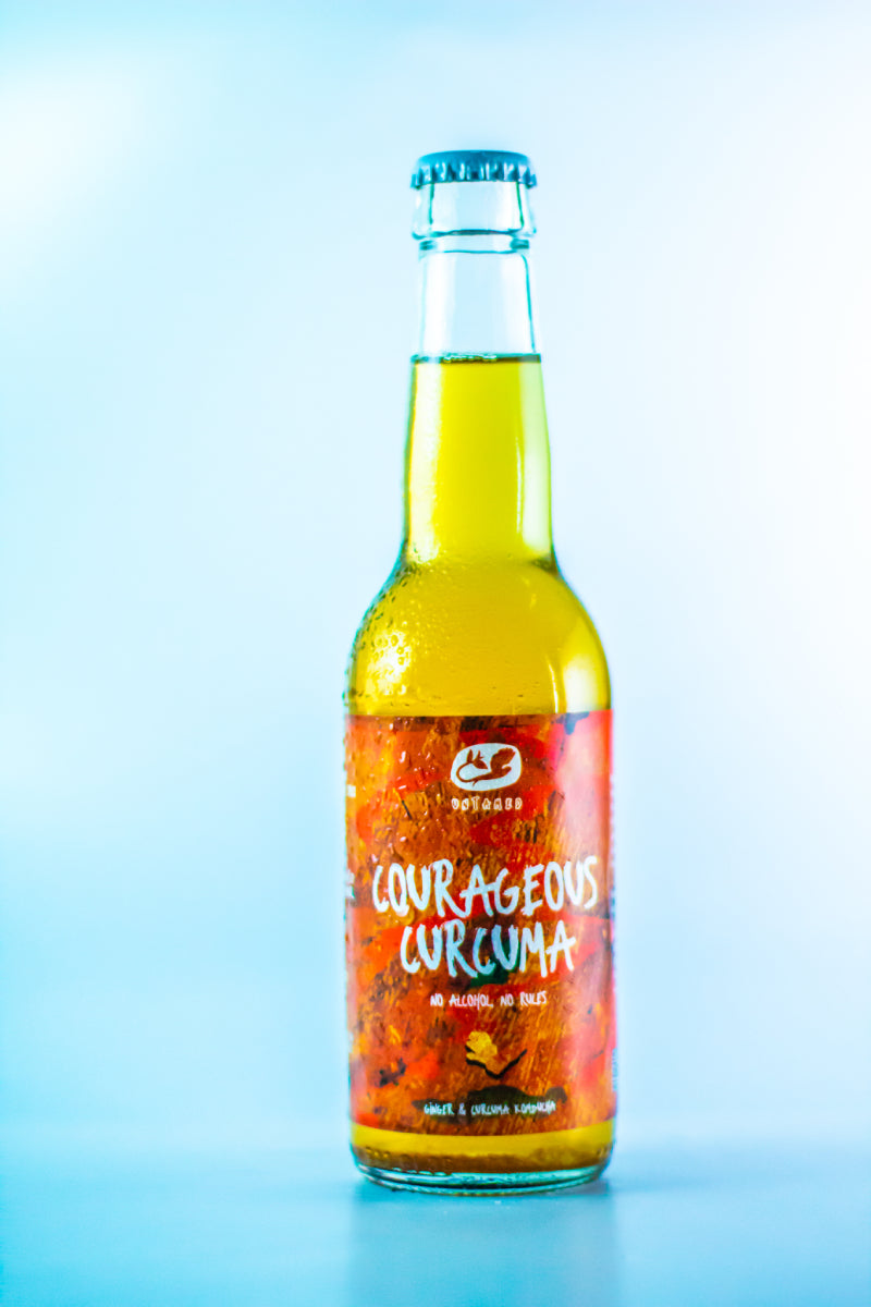 Een enkele fles Courageous Curcuma kombucha met een lege achtergrond