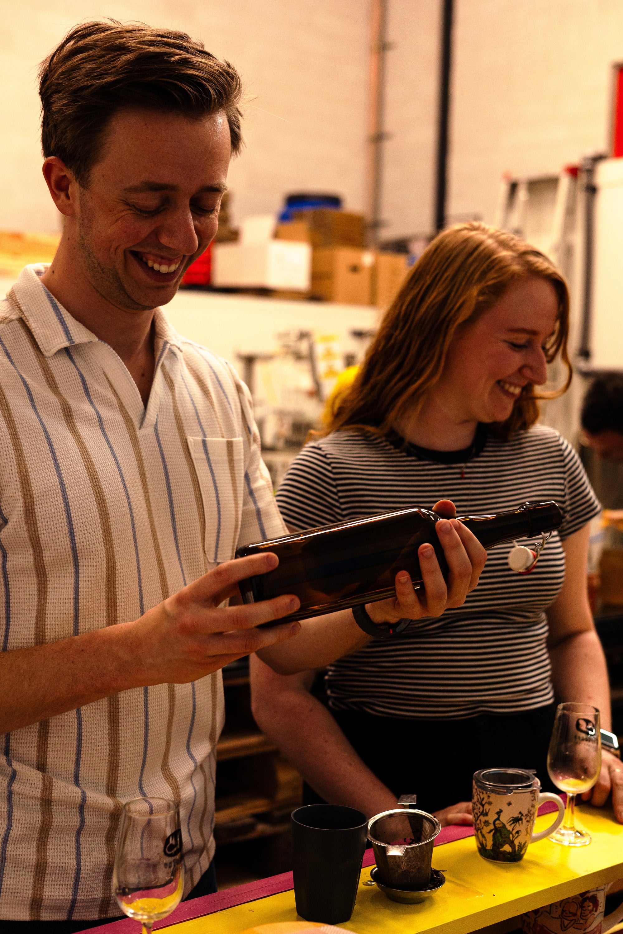 2 workshopdeelnemers houden een fles met beugel vast om de tweede fermentatie van kombucha in te doen 