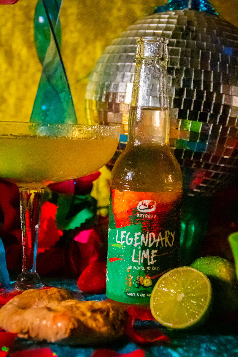 Een flesje Legendary Lime van Untamed Kombucha met een disco achtergrond