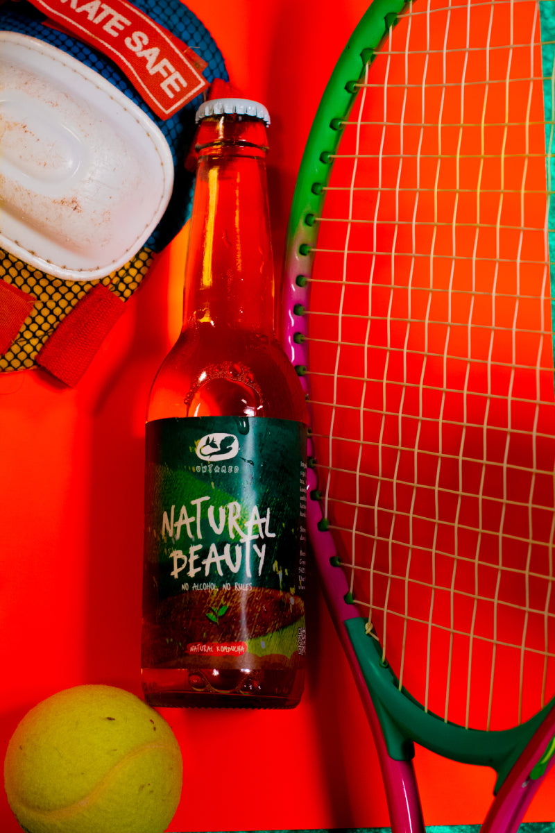 Een flesje Natural Beauty met een speelse en sportieve achtergrond met onder andere een tennisracket